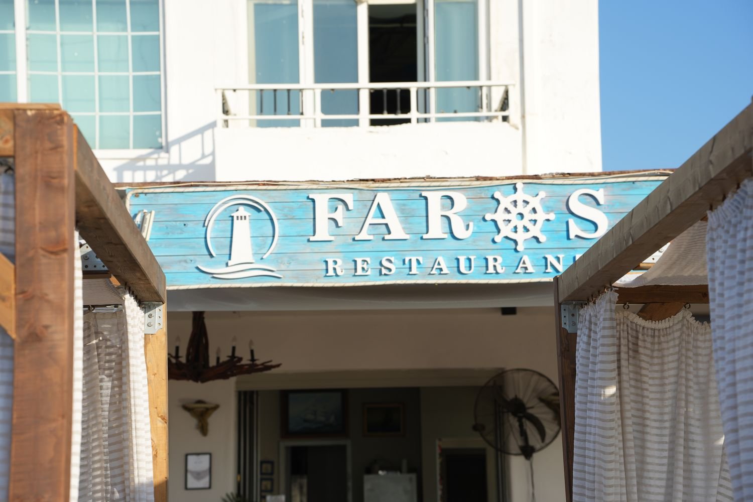 The Faros Restaurant sign above the terrace