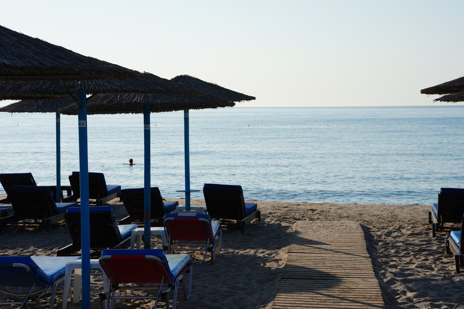 Sunbeds and straw umbrellas at the water's edge